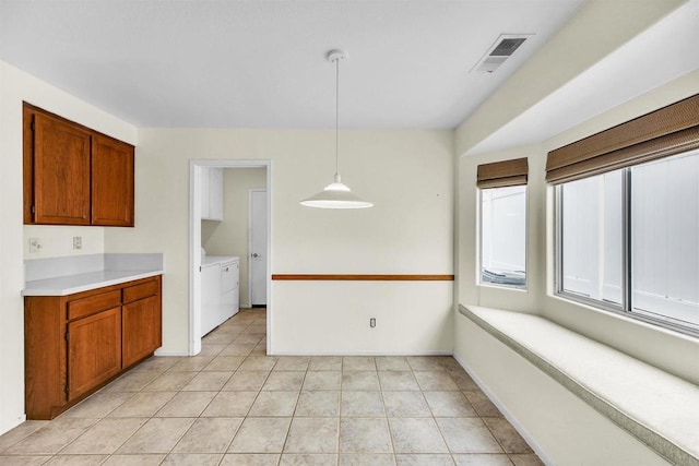 6017 Piros Way, Oceanside, CA 92056 - kitchen featuring visible vents, washer and clothes dryer, brown cabinetry, and light countertops