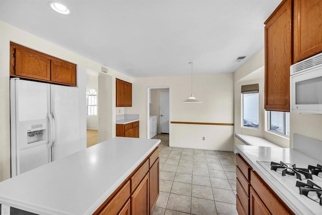 6017 Piros Way, Oceanside, CA 92056 - kitchen featuring brown cabinets, independent washer and dryer, white appliances, light countertops, and visible vents
