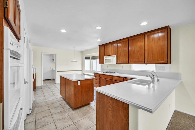 6017 Piros Way, Oceanside, CA 92056 - kitchen with a kitchen island, a sink, light countertops, a peninsula, and white appliances