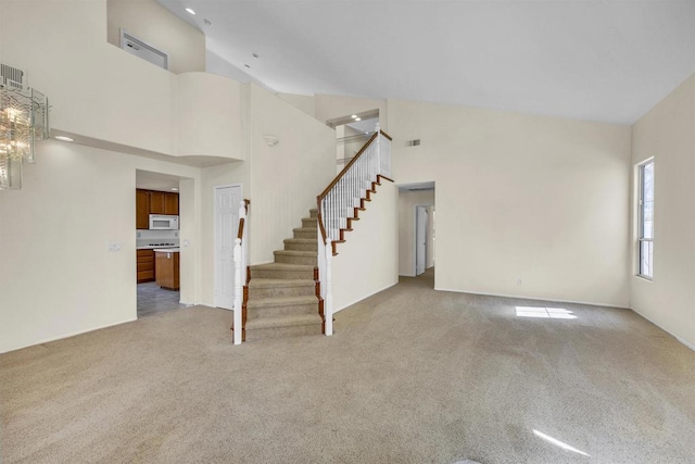 6017 Piros Way, Oceanside, CA 92056 - unfurnished living room with stairs, high vaulted ceiling, and light carpet