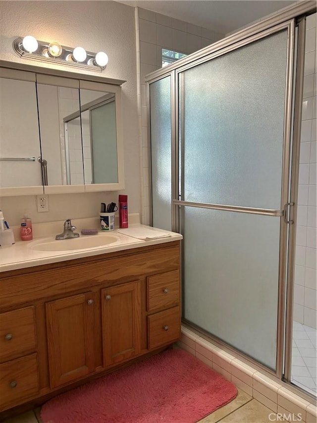 full bath with a shower stall, tile patterned floors, and vanity