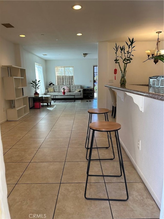 interior space with light tile patterned flooring, an inviting chandelier, baseboards, and recessed lighting