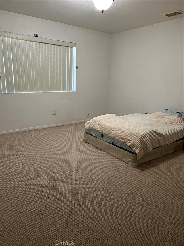 bedroom featuring baseboards, carpet flooring, and visible vents