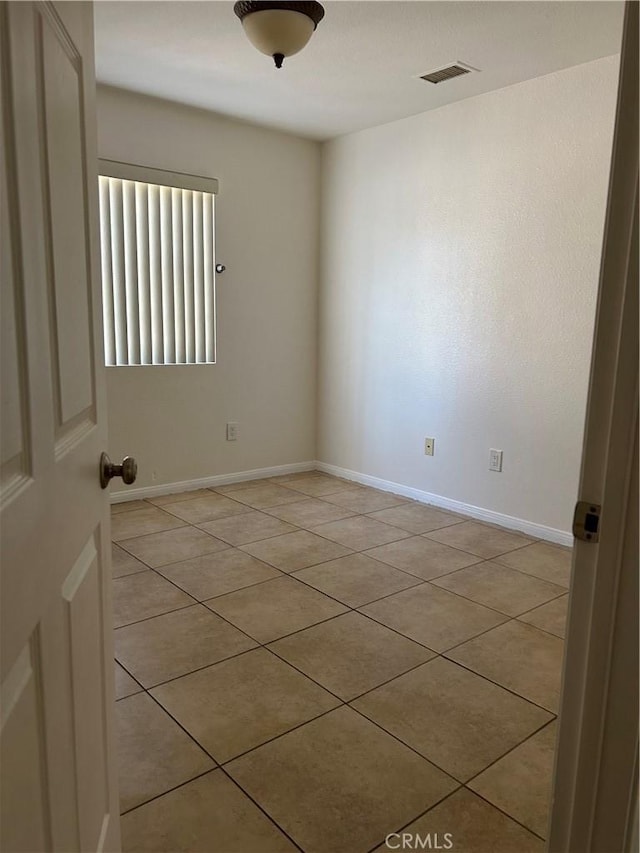 spare room with baseboards, visible vents, and light tile patterned floors