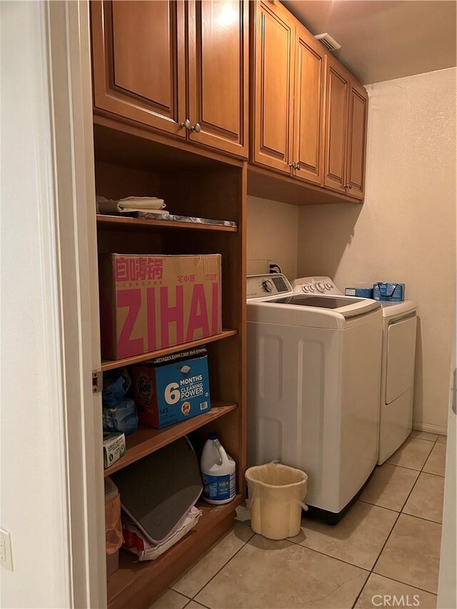 laundry area with washing machine and clothes dryer, cabinet space, visible vents, and light tile patterned flooring