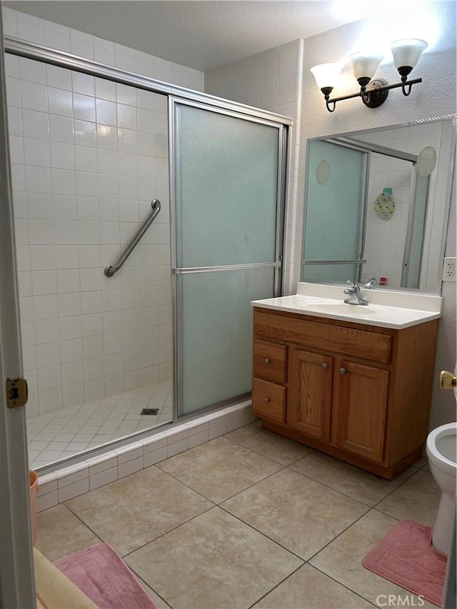 bathroom featuring vanity, tile patterned floors, and a stall shower