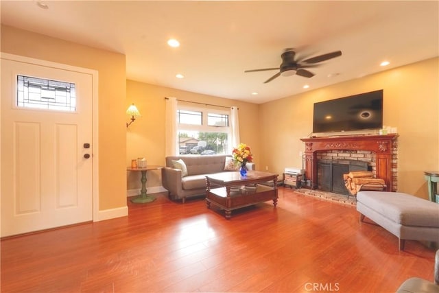 living area with a fireplace, a ceiling fan, recessed lighting, and wood finished floors