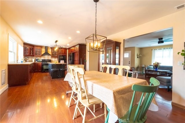 dining area with visible vents, an inviting chandelier, baseboards, recessed lighting, and hardwood / wood-style flooring