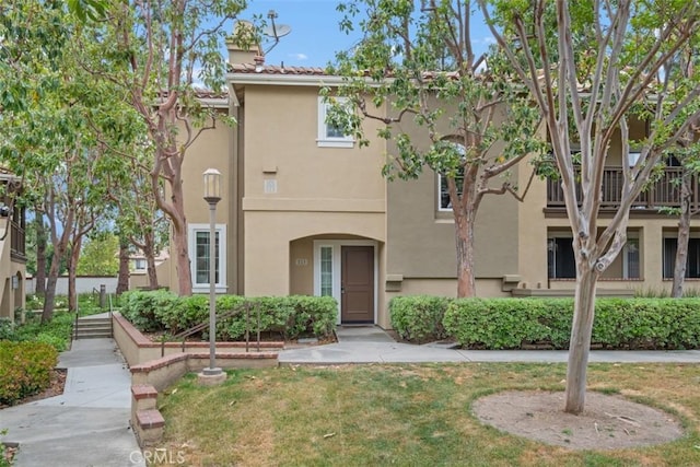 view of front of home with a front lawn and stucco siding