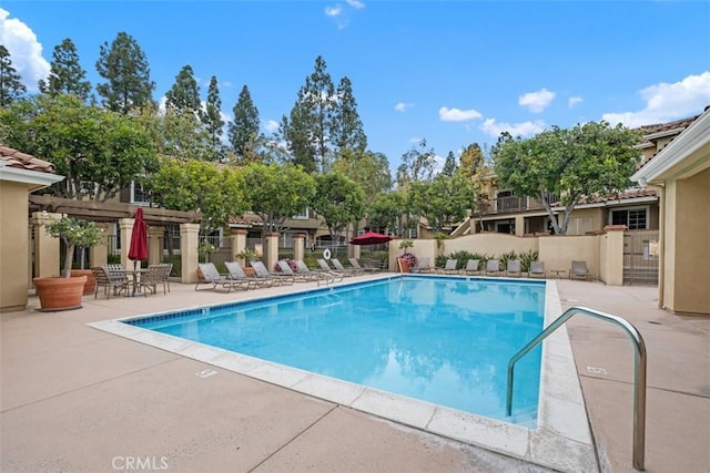 pool featuring a pergola, fence, and a patio area