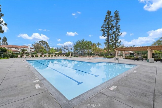 community pool with a pergola and a patio