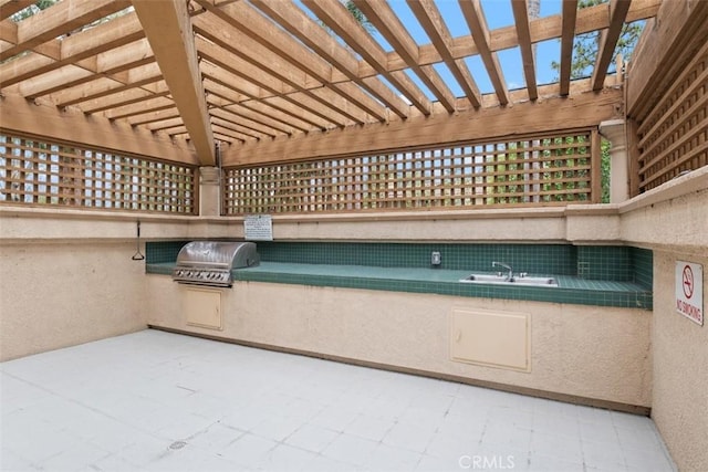 view of patio / terrace featuring a pergola, a sink, a grill, and exterior kitchen