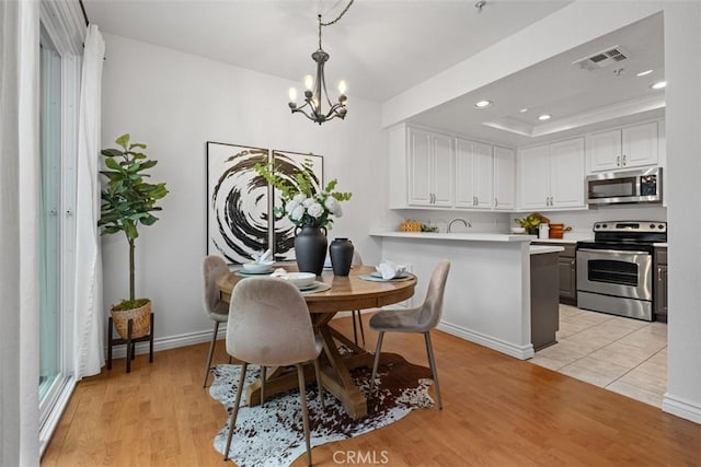 dining area featuring visible vents, a notable chandelier, light wood finished floors, and recessed lighting