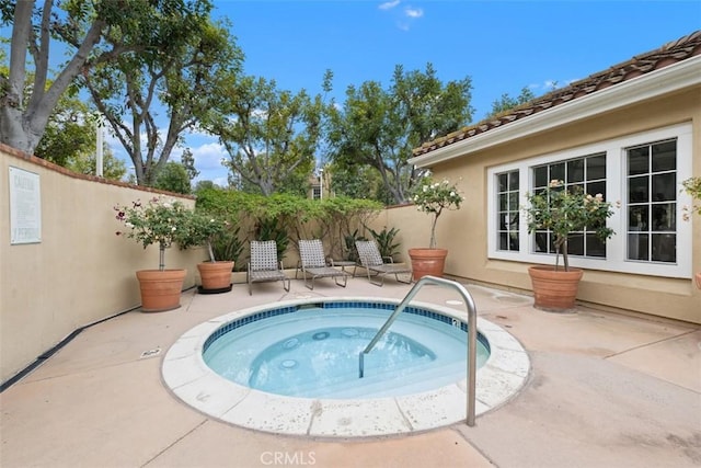 view of swimming pool featuring a fenced backyard, an in ground hot tub, and a patio area