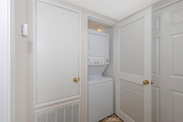 laundry room with visible vents, stacked washer and clothes dryer, and laundry area