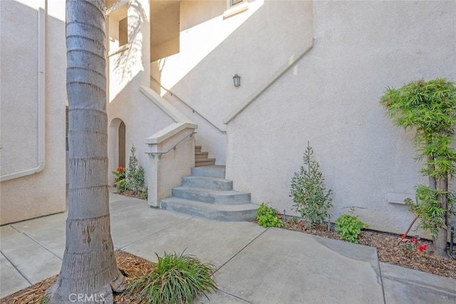 doorway to property featuring stucco siding and a patio area