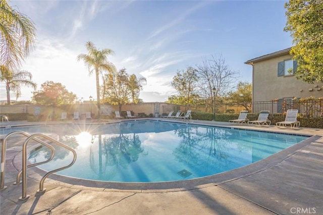 pool with a patio and fence
