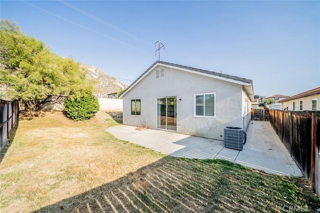 rear view of house featuring cooling unit, a patio, a fenced backyard, stucco siding, and a lawn