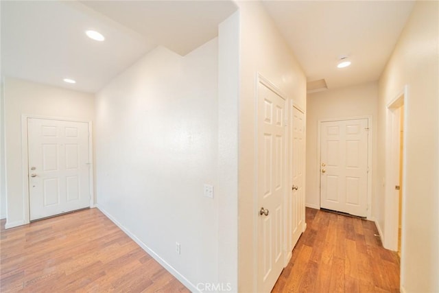corridor with recessed lighting, light wood-style flooring, and baseboards