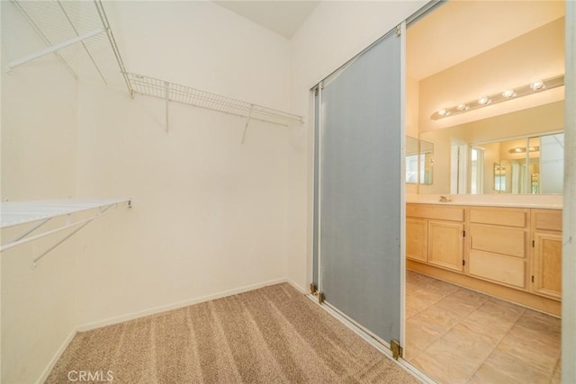 spacious closet featuring light carpet