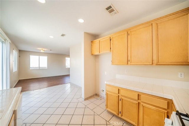 kitchen with visible vents, light tile patterned floors, open floor plan, tile counters, and recessed lighting