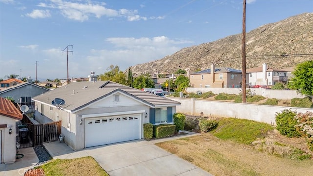 ranch-style house with a garage, a mountain view, a residential view, and fence