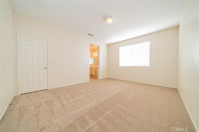 carpeted empty room featuring baseboards and visible vents