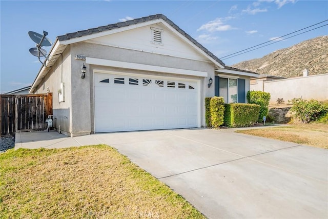 ranch-style house with stucco siding, a garage, fence, and driveway