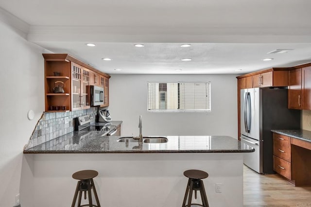 6755 Caminito Del Greco, San Diego, CA 92120 - kitchen with appliances with stainless steel finishes, a sink, dark stone countertops, a breakfast bar area, and recessed lighting