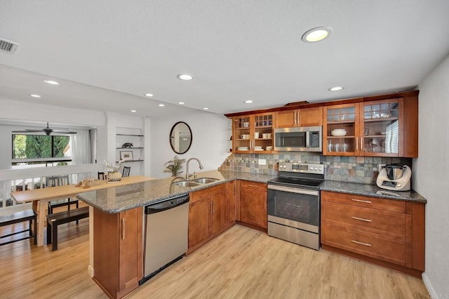 6755 Caminito Del Greco, San Diego, CA 92120 - kitchen featuring stainless steel appliances, a sink, a peninsula, brown cabinets, and light wood-type flooring
