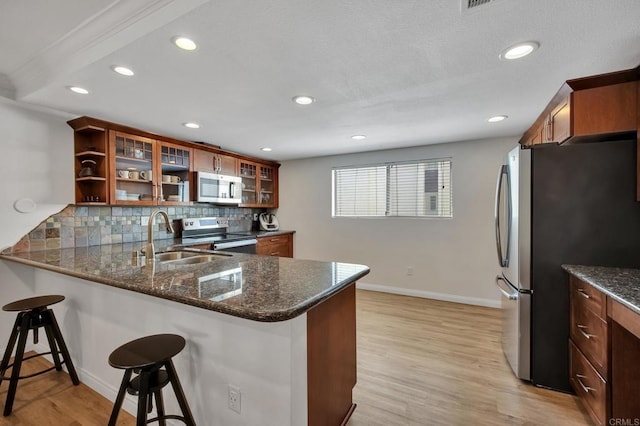 6755 Caminito Del Greco, San Diego, CA 92120 - kitchen featuring stainless steel appliances, a sink, decorative backsplash, baseboards, and a kitchen bar