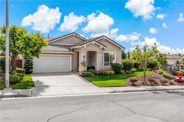 ranch-style home featuring a tiled roof, a front yard, a garage, concrete driveway, and stucco siding