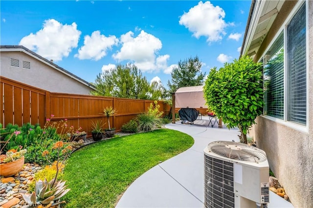 view of yard featuring a fenced backyard, a patio area, and central AC