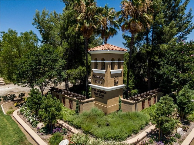 rear view of property featuring a tile roof and stucco siding