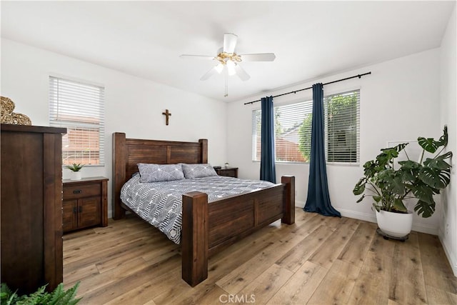 bedroom featuring a ceiling fan, baseboards, and light wood-style flooring