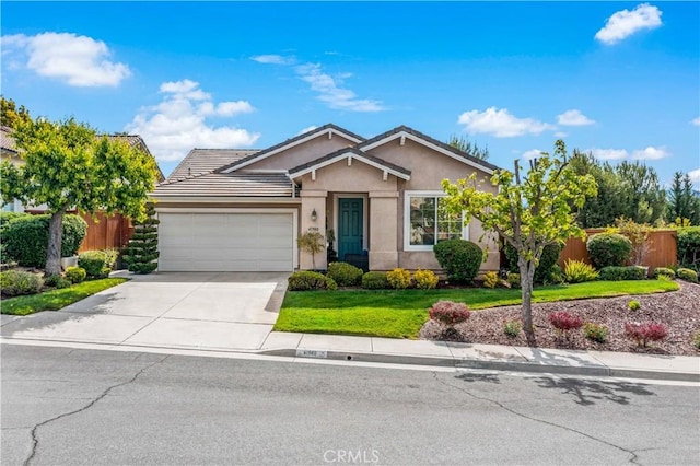 view of front of property with fence, stucco siding, concrete driveway, and a garage
