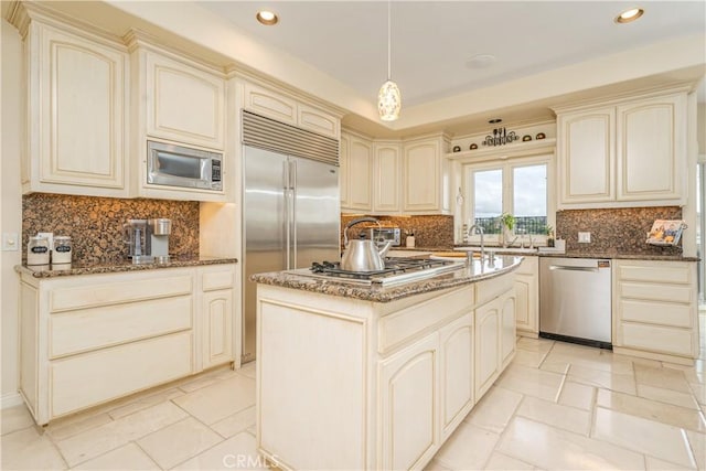 12 Santa Barbara Pl, Laguna Niguel, CA 92677 - kitchen with a center island, cream cabinetry, dark stone countertops, and built in appliances