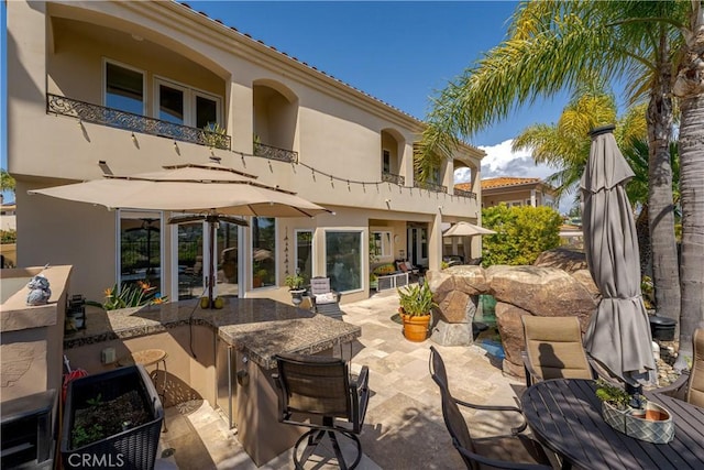 12 Santa Barbara Pl, Laguna Niguel, CA 92677 - rear view of house with a balcony, area for grilling, outdoor dining space, stucco siding, and outdoor wet bar