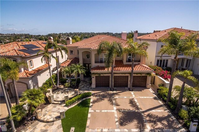 12 Santa Barbara Pl, Laguna Niguel, CA 92677 - mediterranean / spanish house with driveway, a tile roof, a chimney, an attached garage, and stucco siding