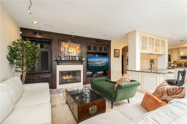 12 Santa Barbara Pl, Laguna Niguel, CA 92677 - living room featuring recessed lighting, light tile patterned floors, a glass covered fireplace, visible vents, and arched walkways