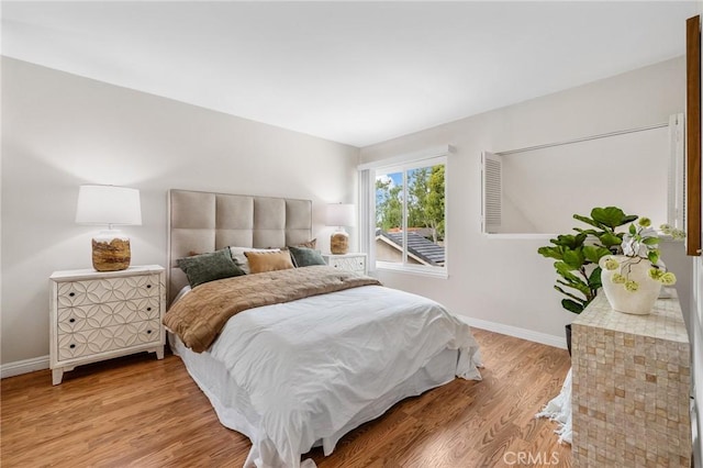 bedroom with light wood-style flooring and baseboards