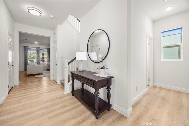 hall with baseboards and light wood-style floors