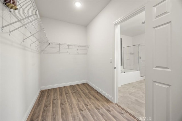walk in closet with wood finished floors