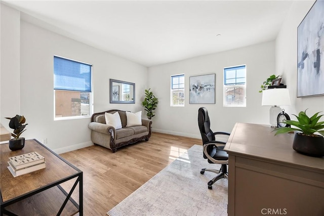 office area with light wood-style floors and baseboards
