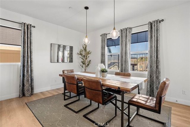 dining area with baseboards and wood finished floors