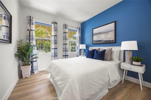 bedroom with baseboards and wood finished floors
