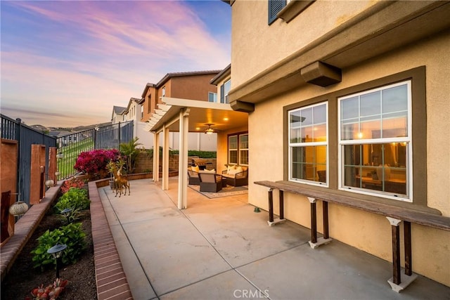 view of patio with an outdoor living space, a ceiling fan, and a fenced backyard