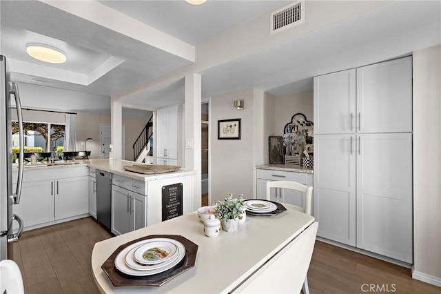 133 Morristown Ln, Costa Mesa, CA 92626 - kitchen with dishwasher, dark wood-type flooring, light countertops, and white cabinetry