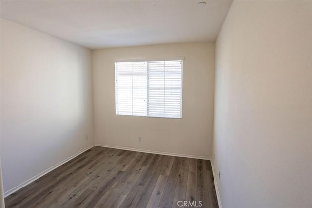 unfurnished room with wood finished floors and baseboards