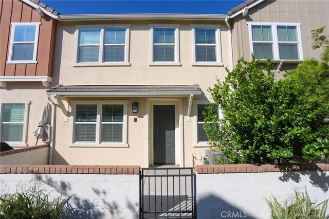 view of property with stucco siding and fence